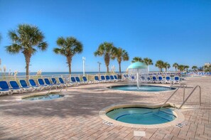 Relax by the pool surrounded by palm trees and a soothing water fountain.
