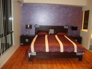 A bedroom with a large bed, two bedside tables, and a window with blinds. - Kooroora House -Spa Bath-Pool- Billard Table (Robina)