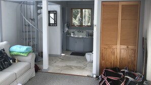 A room with a staircase, a small kitchen area, and a wooden wardrobe. - Katama House w/Guest House w/AC South Beach heated pool. 
Summer weeks avail. 
 (Edgartown)