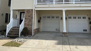 Ein zweigeschossiges Wohnhaus mit Veranda, Garage und einem Balkon im oberen Geschoss.