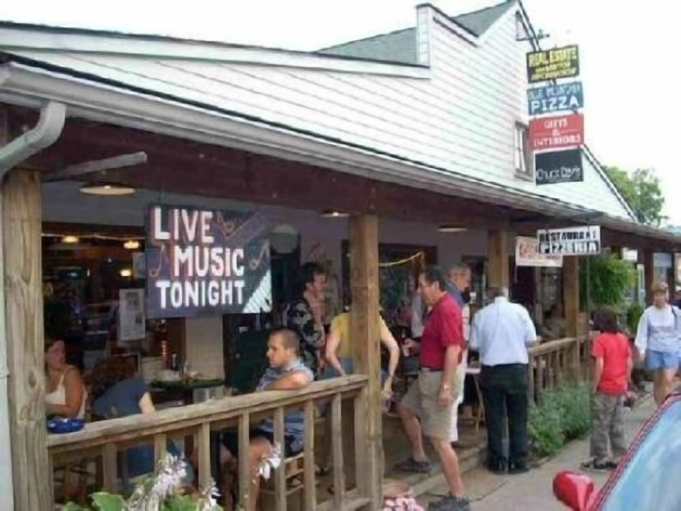 A restaurant with outdoor seating and a sign advertising live music tonight.
