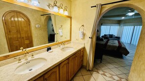 Ein Badezimmer mit zwei Waschbecken, einem großen Spiegel und Holzschränken.