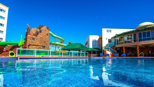 En swimmingpool med vandrutsjebane og klippeformation.