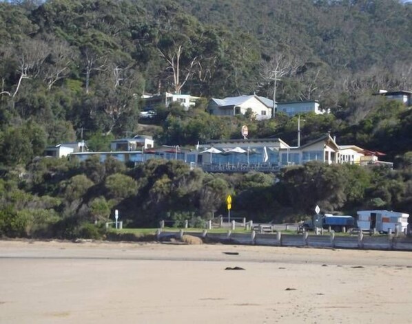 A coastal area with houses on a hillside, a road, and a beach. - Kenmaure -A cosy retreat (Wye River)