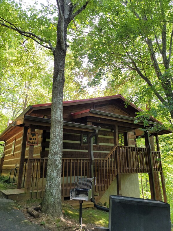 A rustic cabin with a wooden exterior, a porch, and a 'Bear Naked' sign. - Honeymoon Cabin, Very Secluded, Very Romantic, Arcade, FREE Daily Bear Sightings (Gatlinburg)