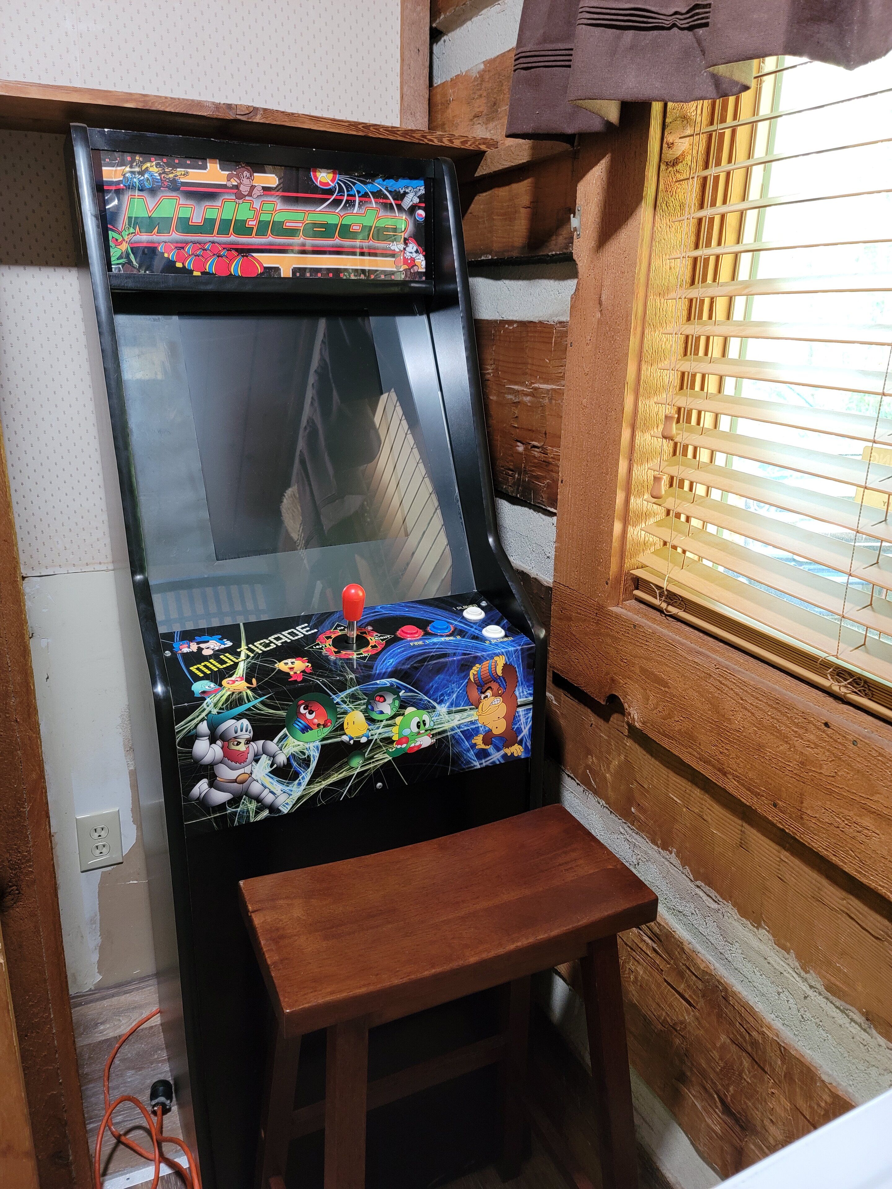 A video game arcade machine with a wooden base and a glass panel.