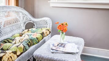A wicker sofa and table set against a wall with a window.