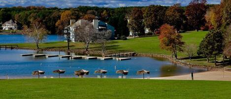 A lakeside property with a dock, a grassy area, and a large house.