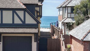 A coastal residential area with houses featuring gabled roofs and a view of the ocean. - Gated Fairytale Estate | Lakefront w/ Ocean Views (Oceanside)