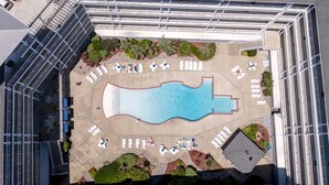 An aerial view of a rooftop pool with lounge chairs and a small garden area. - Seaside Delight | 350 ft from the beach | Community Pool (Virginia Beach)