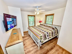 A bedroom with a bed, a desk, a TV, and a ceiling fan. - Four Seasons Vacation Home By Lake,  HOT TUB, WIFI,BEACH passes, Canoe, FIRE PIT (Lake Harmony)
