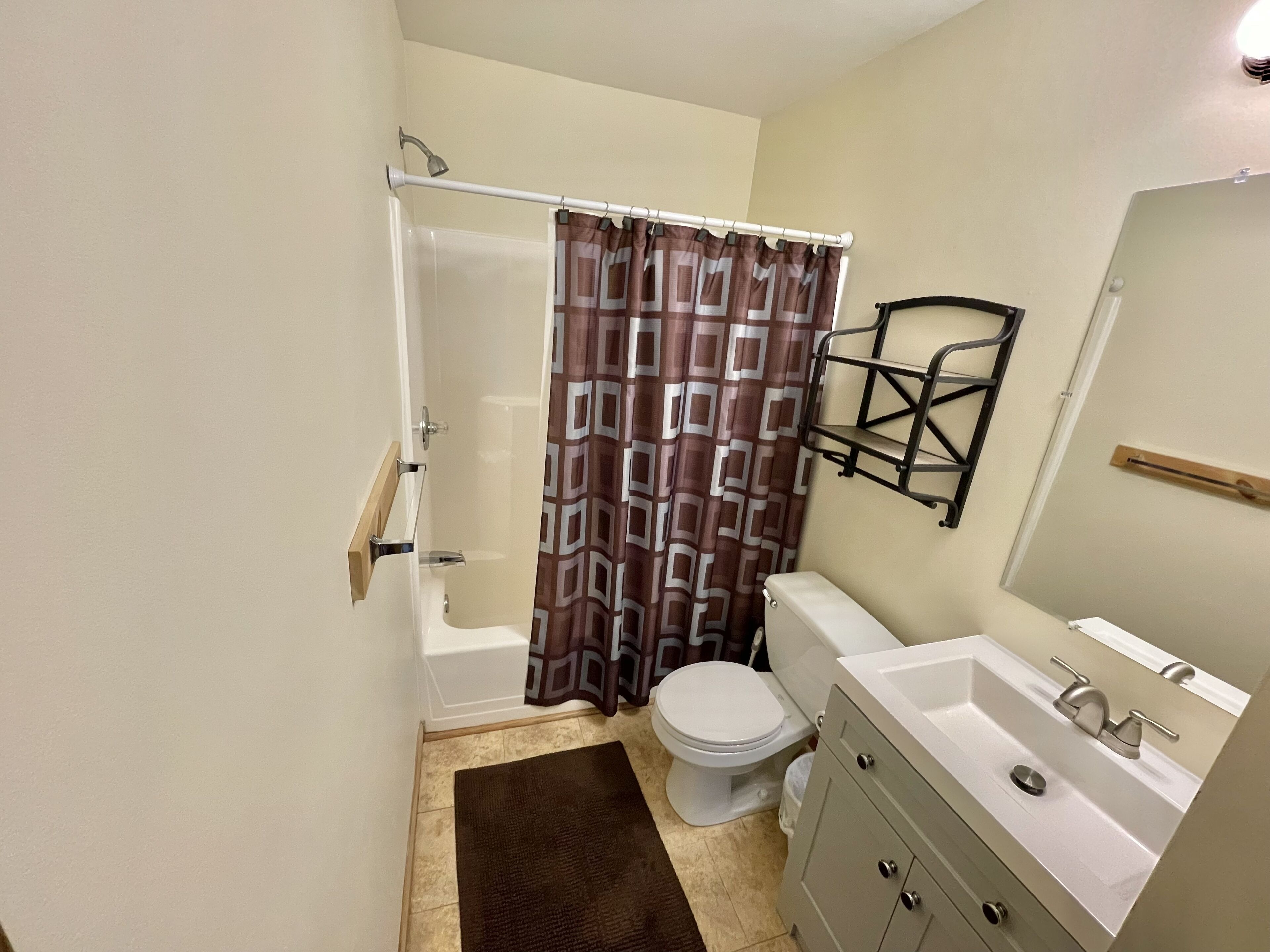 Een kleine badkamer met douche, toilet en wastafel.