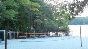 A sandy beach with a volleyball net, benches, and picnic tables. - Four Seasons Vacation Home By Lake,  HOT TUB, WIFI,BEACH passes, Canoe, FIRE PIT (Lake Harmony)