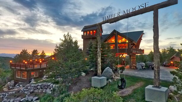 Une grande cabane en rondins sur laquelle est accrochée une enseigne indiquant « TIMBER MOOSE ».