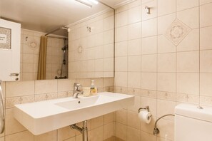 A bathroom with a white sink, a mirror, and a shower. - Walking distance to all attractions, safe, superb (Athina)