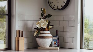 Un plan de travail de cuisine agrémenté d’un vase décoratif, d’une bouteille de vin et d’un porte-couteaux.