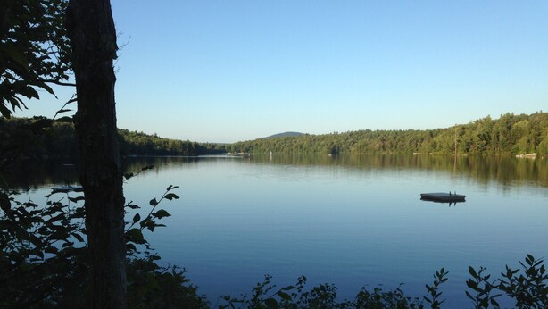 A calm lake surrounded by dense forest. - Private Beach And  Mountain Lake Home (Washington)