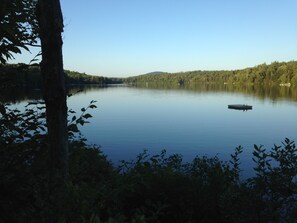 A calm lake surrounded by dense forest. - Private Beach And  Mountain Lake Home (Washington)
