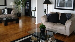 A modern living room with a sofa, coffee table, and bookshelf. - Gorgeous Waterfront Home with Spectacular Views! Book Your Getaway Now!  (Lavallette)