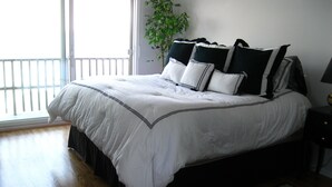 A bedroom with a large bed, a potted plant, and a view of the outdoors. - Gorgeous Waterfront Home with Spectacular Views! Book Your Getaway Now!  (Lavallette)