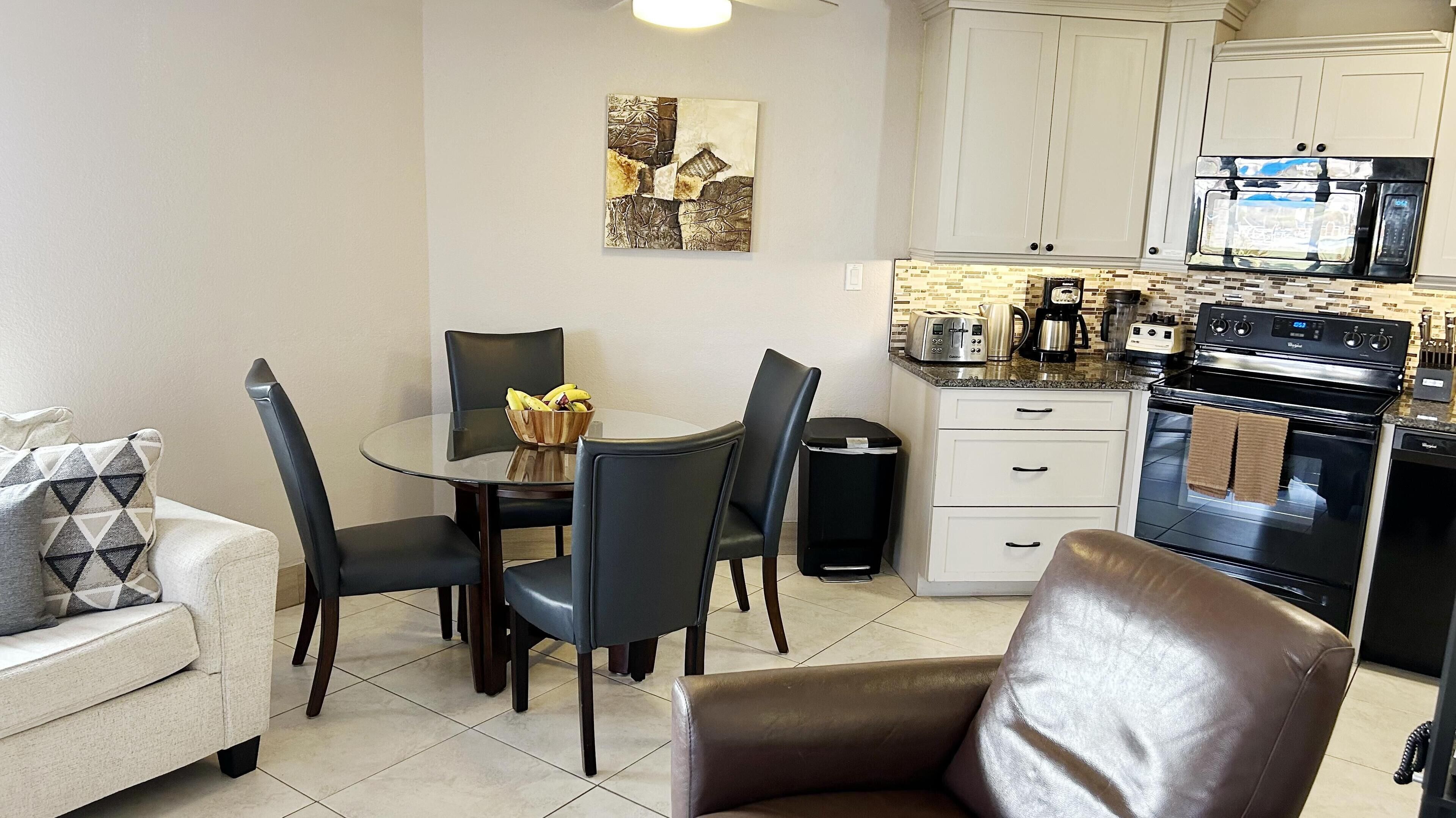Un espacio habitable compacto con comedor, kitchenette y sofá.