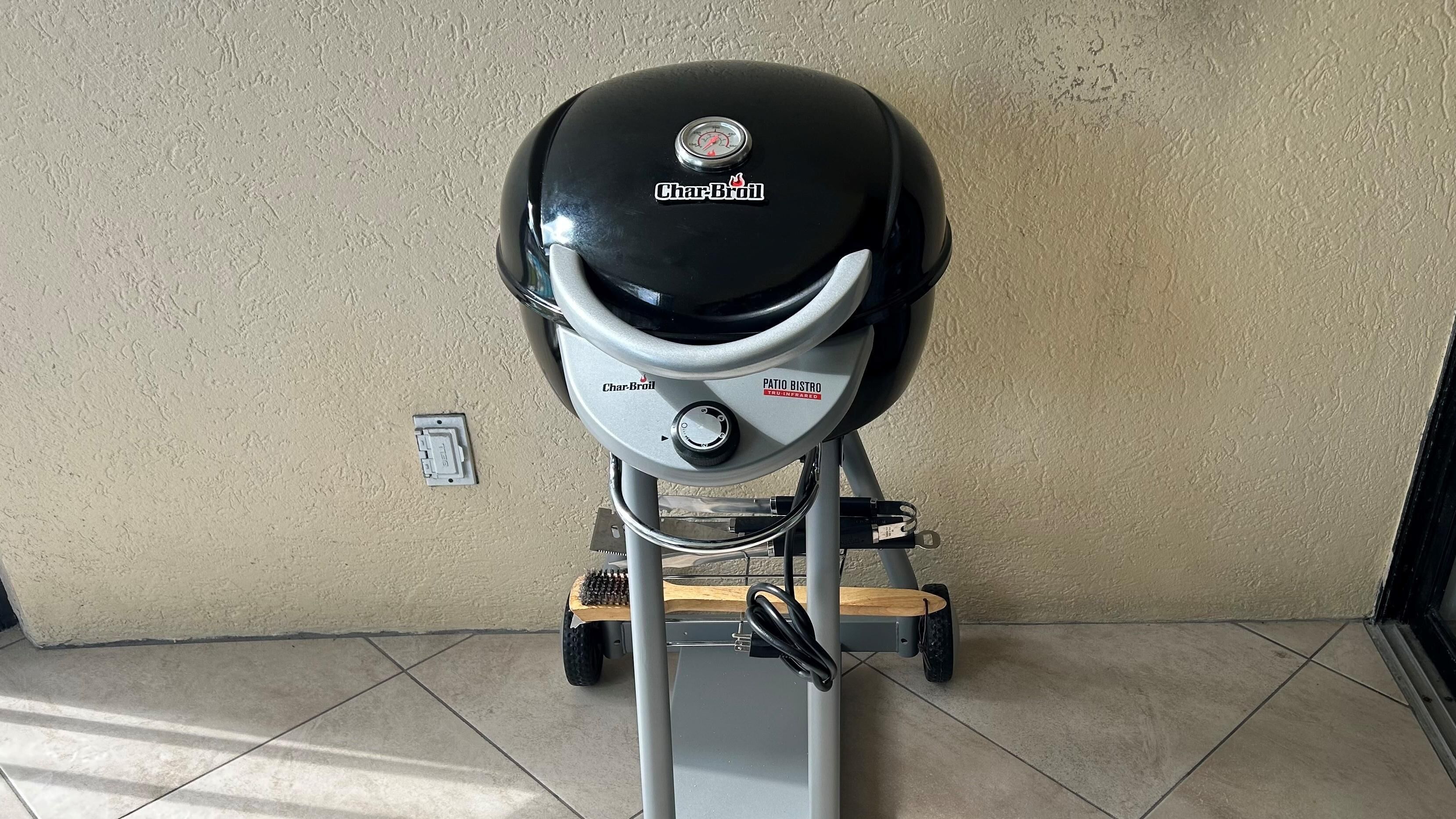 A Char-Broil patio bistro grill with a control panel, mounted on a stand with wheels.