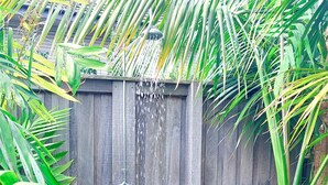 Une clôture en bois avec un tuyau d’eau.