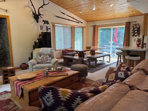 A cozy living room with a fireplace, a dining area, and a view of the outdoors. - Cozy Kings Beach cabin close to downtown and Lake (Tahoe Vista)