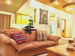 A cozy living room with a leather sofa, a wooden coffee table, and a bear plush toy. - Cozy Kings Beach cabin close to downtown and Lake (Tahoe Vista)