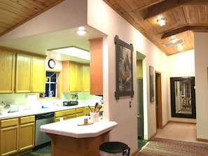 A kitchen with wooden cabinets, a central island, and a refrigerator. - Cozy Kings Beach cabin close to downtown and Lake (Tahoe Vista)