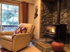 A cozy living room with a stone fireplace, a leather armchair, and a television. - Cozy Kings Beach cabin close to downtown and Lake (Tahoe Vista)