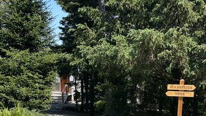 A gravel path leading to a wooden signpost with directions to 'Sea Breezes' and 'Tides'.