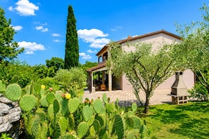Una casa con un patio, rodeada de cactus y árboles.