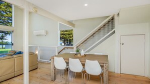 Une cuisine moderne avec un coin repas, un escalier et une vue sur l’extérieur.