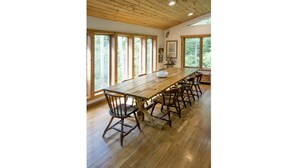 A long wooden dining table with six chairs, large windows, and a wooden ceiling. - STUNNING  VACATION AND SKI HOME - Hudson Valley, Woodstock, Hunter (Palenville)