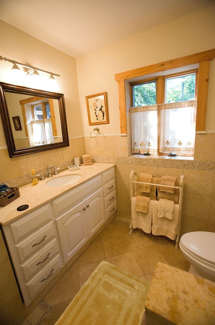 Une salle de bain équipée d’un lavabo, d’un miroir, d’une fenêtre et d’un porte-serviettes.