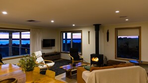 Un salon confortable avec une cheminée, un téléviseur et une vue sur l’eau.