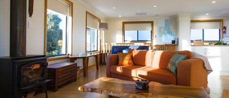 A cozy living room with a wooden coffee table, a sofa, and a fireplace.