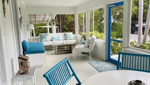 A bright, white room with a white sofa, blue chairs, and a table.