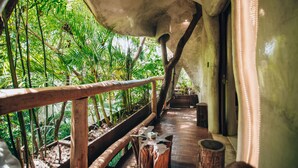 An indoor walkway with wooden railings, surrounded by lush greenery and a wooden floor. - Orchid House Tulum Jungle (Tulum)