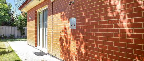 A red brick building with a door and a small window.