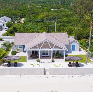 Situated on a well-maintained lawn, this two-story home offers a covered front porch and multiple outdoor seating areas.