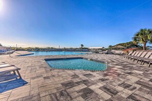 Une piscine avec des chaises longues et un palmier.