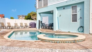 A swimming pool with a tiled deck, surrounded by lounge chairs and a covered patio area. -   160 inch pool tv plus 120 inch great room tv  6 Bed  5 Bath Pool and hot tub (Fort Myers Beach)