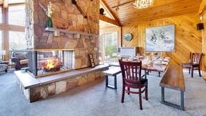 A cozy interior with a stone fireplace, wooden ceiling, and a dining area. - Repeat Retreat — Your Place to Come Back To! (Lake Harmony)