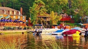 A lakeside hotel with outdoor seating and boats docked. - Repeat Retreat — Your Place to Come Back To! (Lake Harmony)