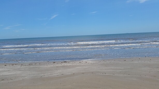 A beach with waves approaching the shore.