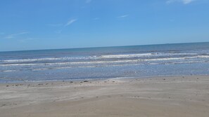 Una playa con olas acercándose a la orilla.