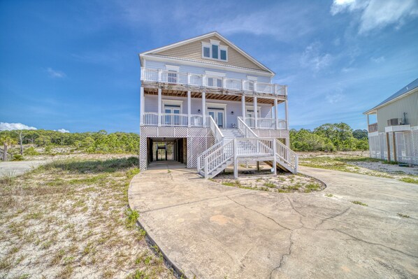 A two-story house with a balcony and a staircase leading to the entrance.