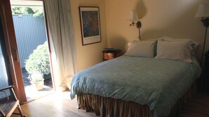 A bedroom with a bed, a nightstand, a lamp, a window with curtains, and a door leading to a balcony. - Private En Suite Large Master Bedroom With King Sized Bed   (Burlington)